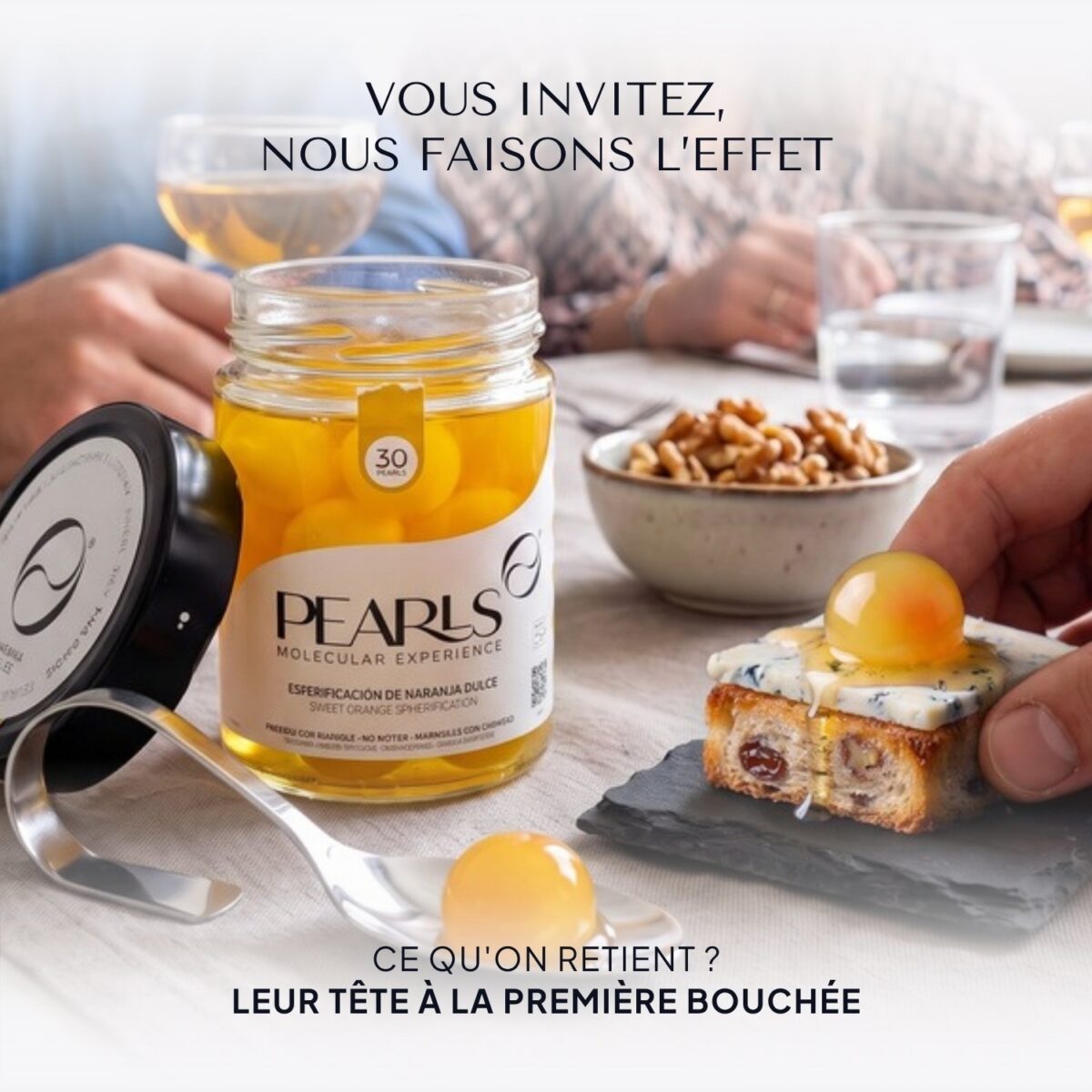 Pot ouvert de Pearls Orange douce sur la table avec des noix et un toast au bleu ; une main prend une Pearl