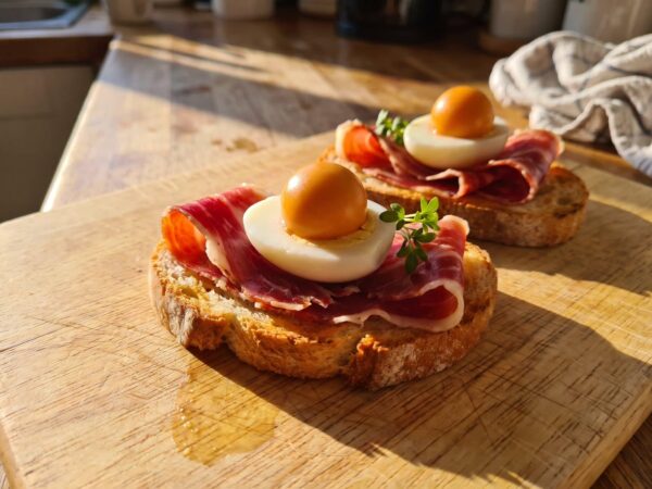 Deux toasts au jambon ibérique, avec un demi-œuf de caille et une Pearl de Gazpacho à la place du jaune