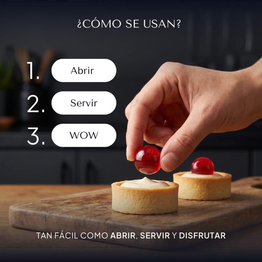 Mano colocando con los dedos una esferificación de frambuesa sobre una tartaleta con crema