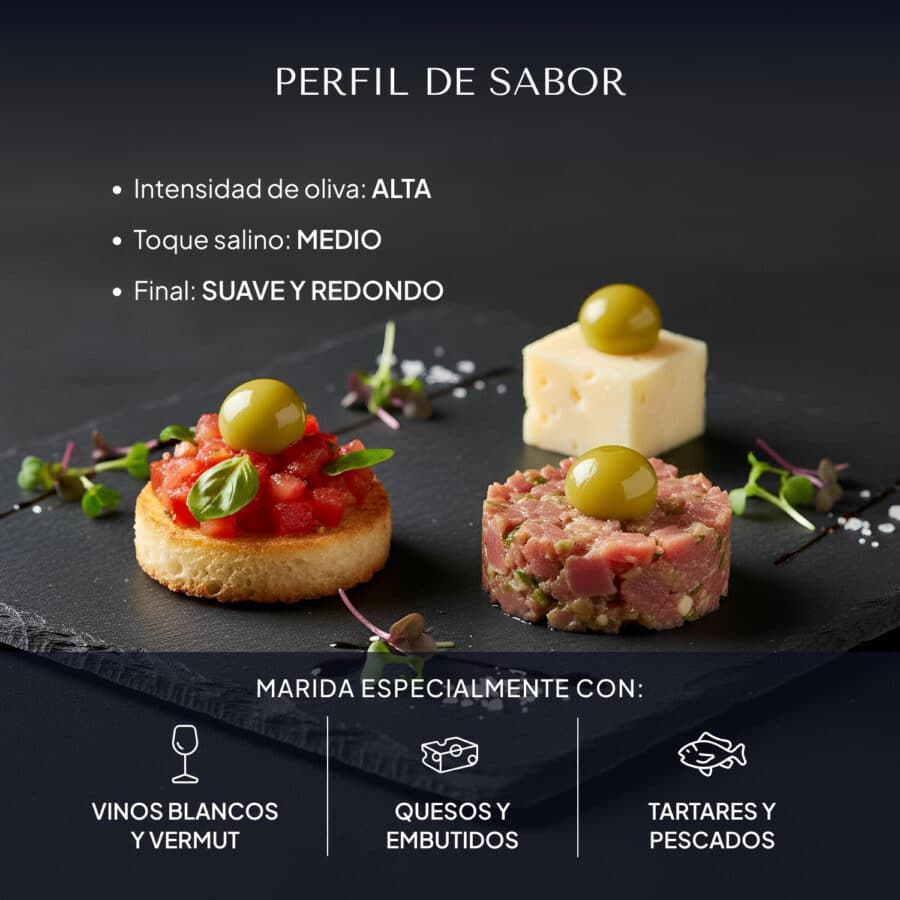 Pizarra con tres bocados de maridaje —tosta de tomate, queso y tartar— coronados con Pearls de oliva verde