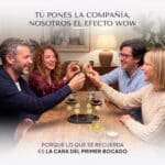 Cuatro amigos en casa brindan con una Pearl de Limoncello entre los dedos, con cafés, la bandeja con soportes y el frasco