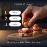 Mano colocando con los dedos una Pearl de gazpacho sobre una tosta de jamón ibérico y huevo de codorniz