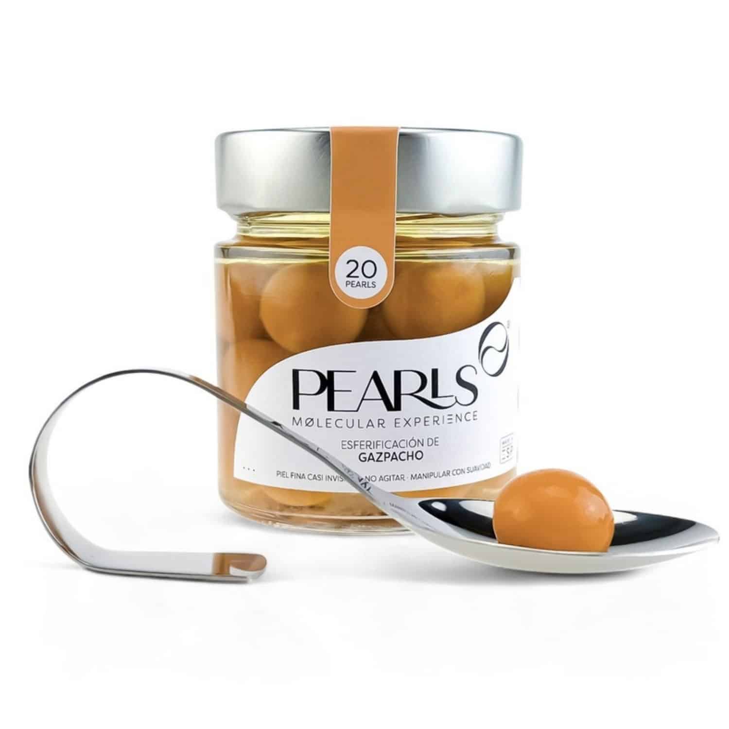 Frasco de esferificaciones de gazpacho Pearls con la cucharilla de servicio y una Pearl, sobre fondo blanco