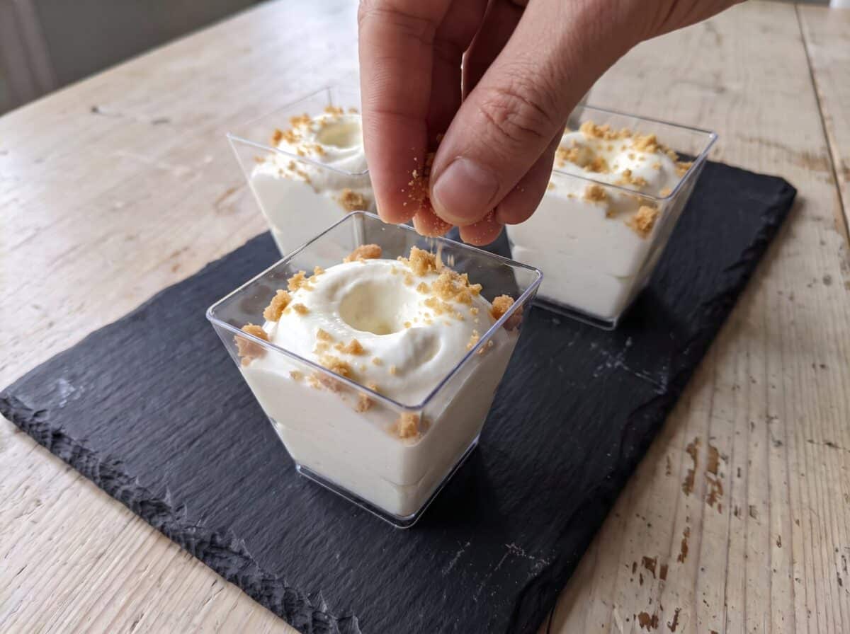 Espolvoreando el crumble de galleta por encima de la mousse de limón
