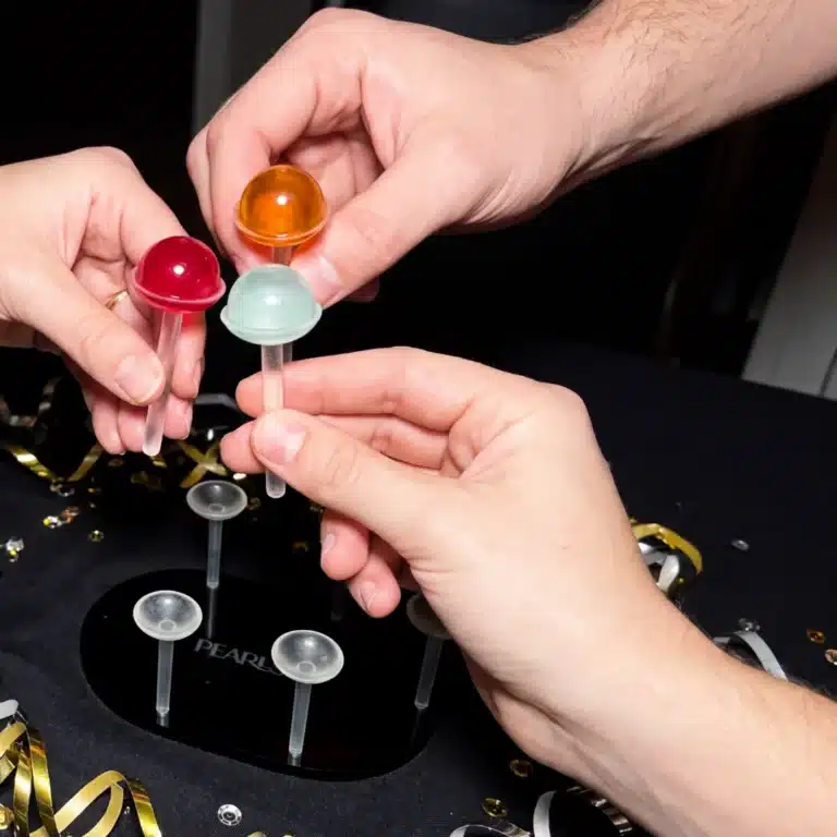 Manos sujetando Pearls de colores en sus soportes