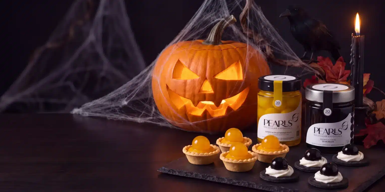 Mesa de Halloween con calabaza tallada, tartaletas con Pearls de Naranja Dulce y bocados con Pearls de Oliva Negra, junto a sus frascos