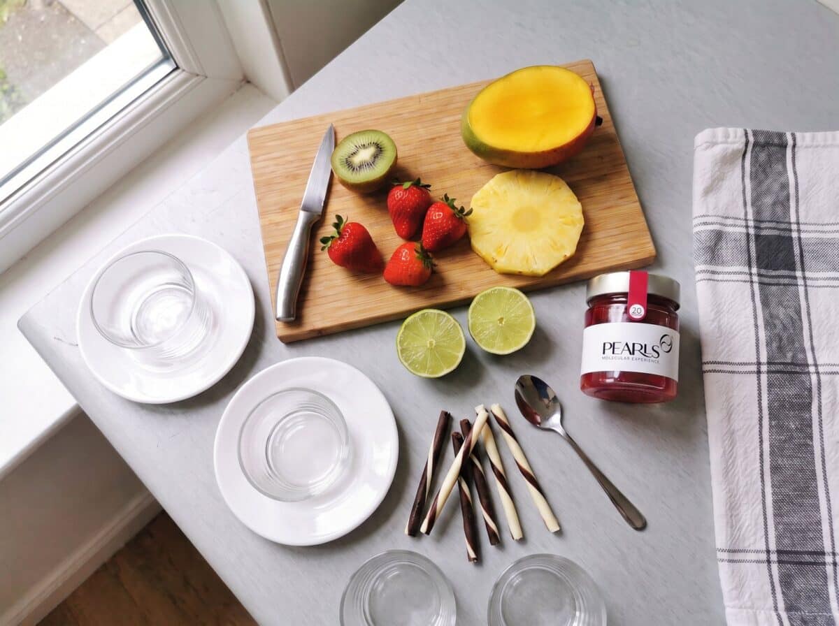 Ingredientes: kiwi, fresas, mango, piña, lima, barquillos de chocolate y frasco de Pearls de Frambuesa