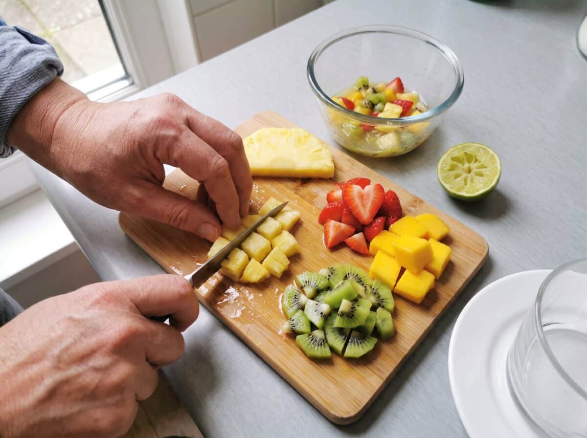 Cortando la fruta en dados de 1 cm sobre una tabla