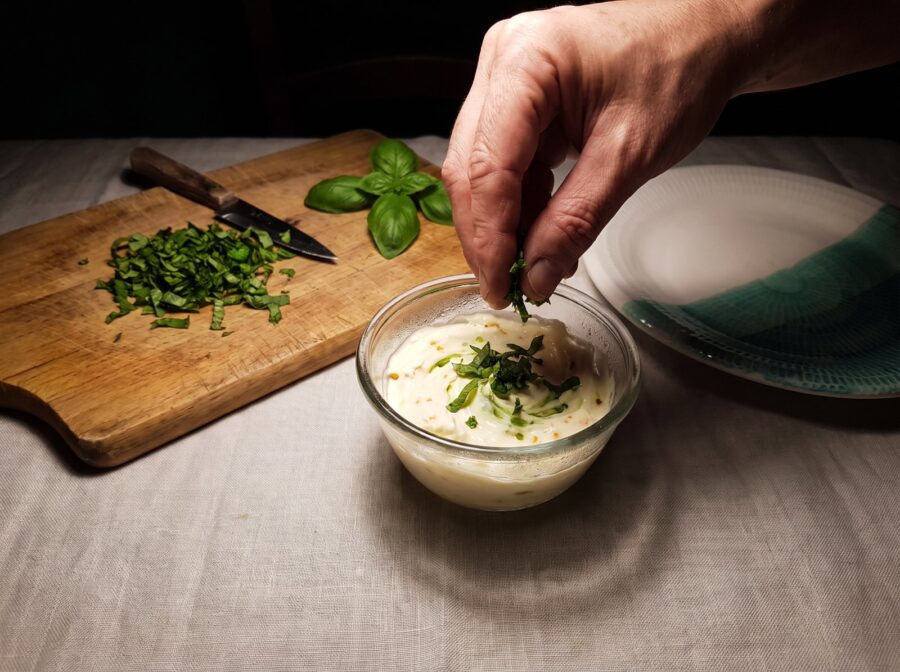 Añadiendo albahaca picada a la crema de mascarpone y naranja