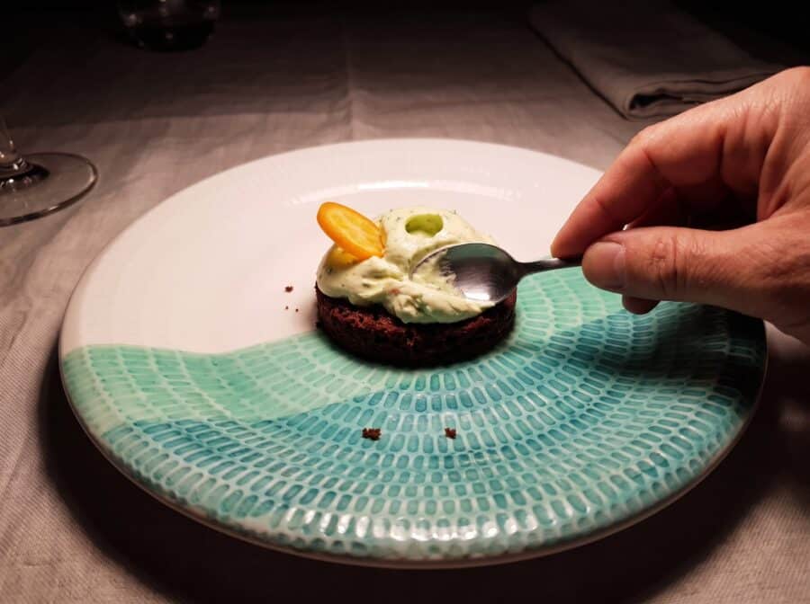 Disco de bizcocho de chocolate con cúpula de crema y rodaja de kumquat